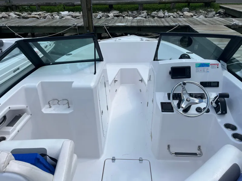 Slide: The Image of 2024 Aquasport 2200 Dual Console boat interior with steering wheel and dashboard controls. - 2
