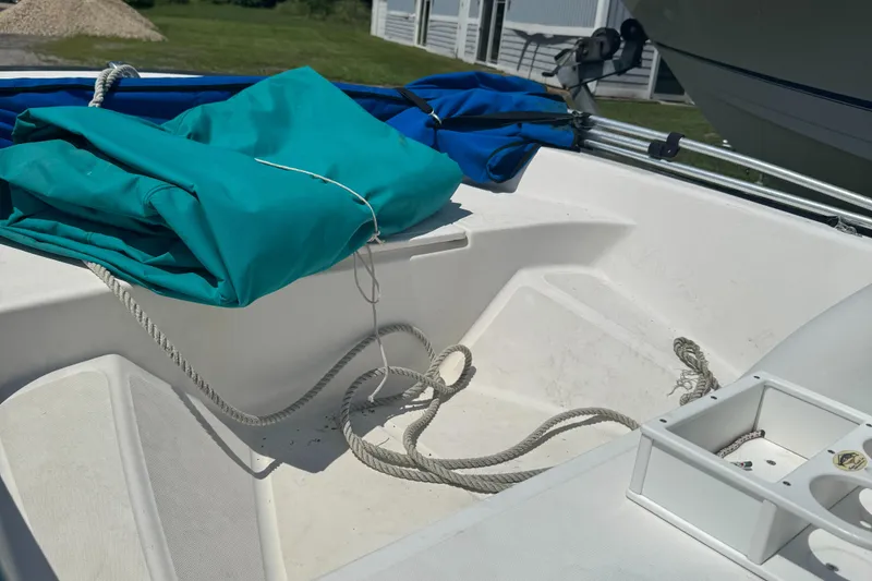 Slide: The Image of Boston Whaler Sport 13 boat interior with ropes and folded teal cover, 2000 model. - 2
