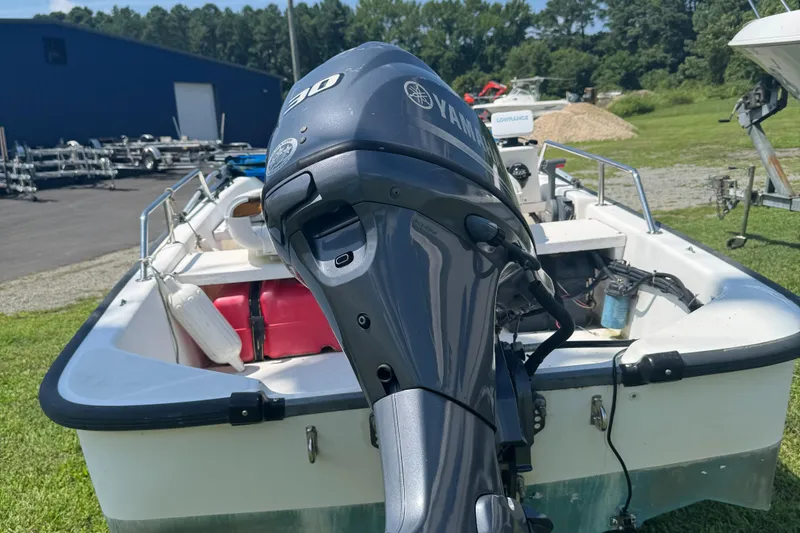 Slide: The Image of Boston Whaler Sport 13 boat with Yamaha outboard motor, parked on grass. - 7