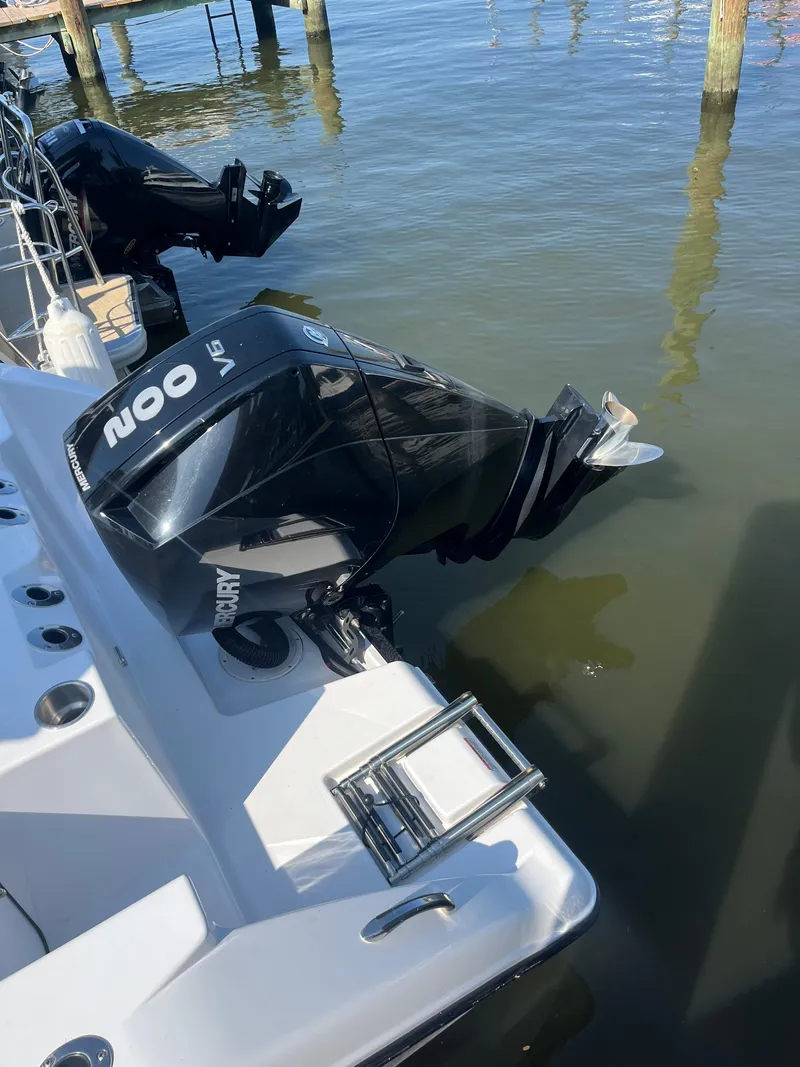 Slide: The Image of 2024 Aquasport 2200 Dual Console with Mercury outboard engine at dockside. - 10