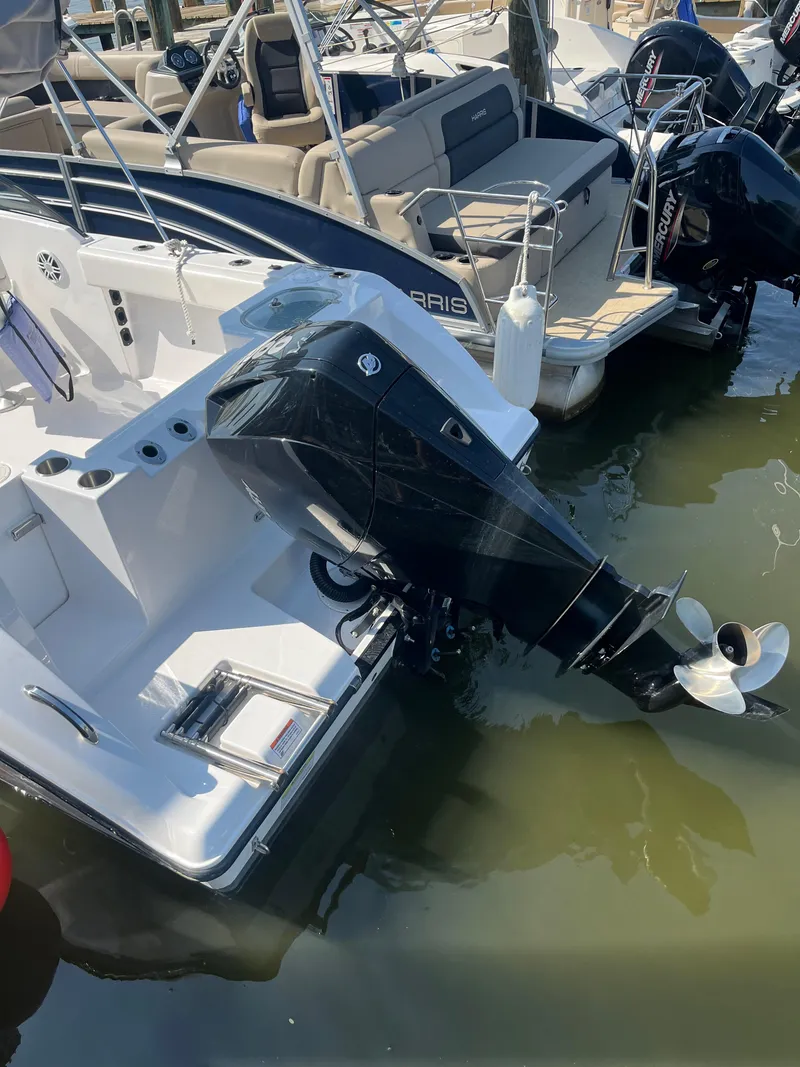 Slide: The Image of 2024 Aquasport 2200 Dual Console boat with outboard motor at dock. - 11