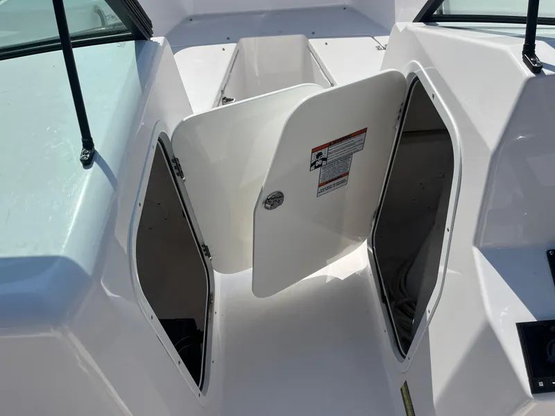 Slide: The Image of 2024 Aquasport 2200 Dual Console boat storage compartments open on deck. - 7