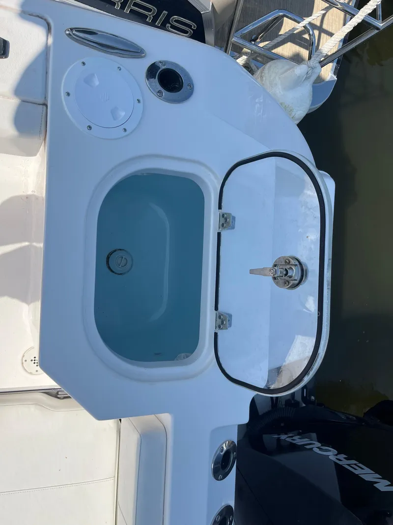 Slide: The Image of 2024 Aquasport 2200 Dual Console boat with open livewell and faucet. - 8