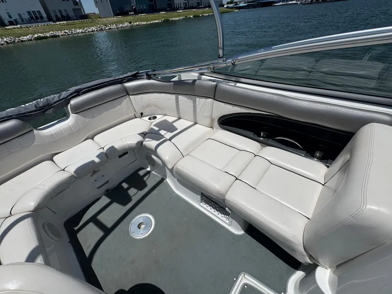 Slide: The Image of 2007 Yamaha Boats AR230 HO interior with white seating, docked by a scenic waterfront. - 16
