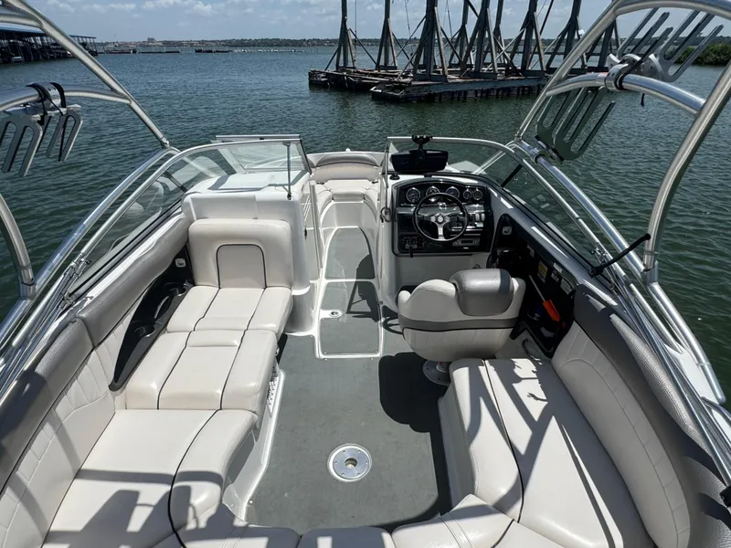 Slide: The Image of 2007 Yamaha Boats AR230 HO interior with seating and steering, docked by the water. - 20