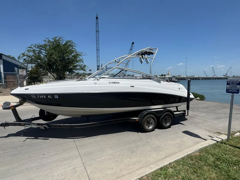 Slide: The Image of 2007 Yamaha AR230 HO boat on trailer near waterfront, clear sky background. - 8