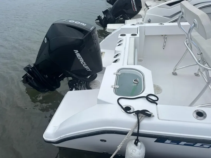 Slide: The Image of 2023 Aquasport 2200 Center Console boat with Mercury outboard engine on water. - 2