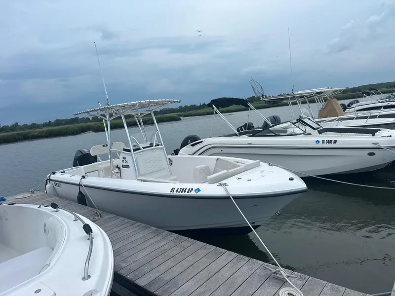 Slide: The Image of 2023 Aquasport 2200 Center Console boat docked at a marina. - 4