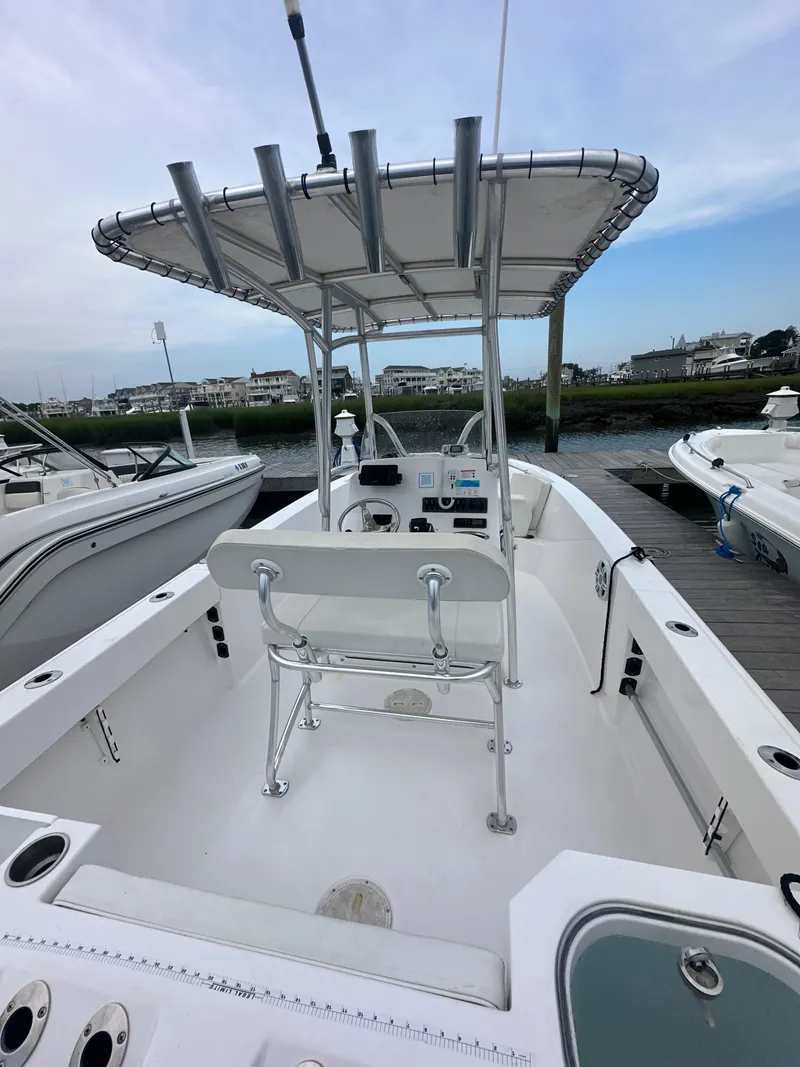 Slide: The Image of 2023 Aquasport 2200 Center Console boat docked, featuring a sleek design and spacious deck. - 5