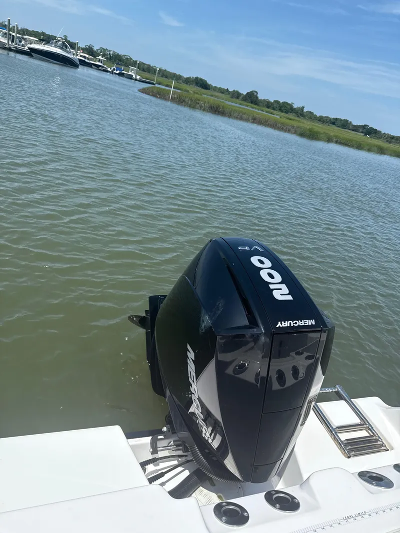 Slide: The Image of 2023 Aquasport 2200 Center Console with Mercury outboard motor on calm water. - 9