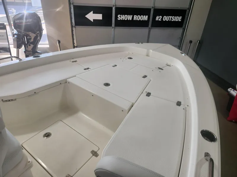 Slide: The Image of 2025 Pathfinder 2200 TRS boat interior with storage compartments, showroom setting. - 11