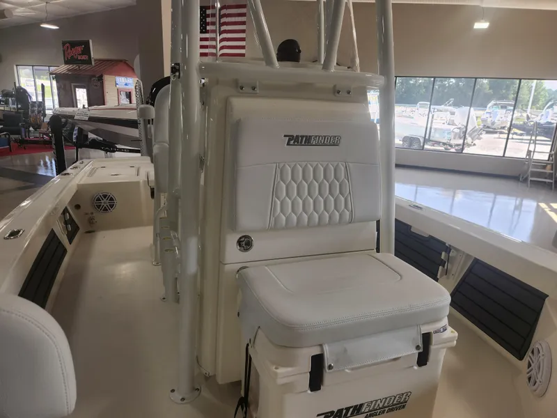 Slide: The Image of 2025 Pathfinder 2200 TRS boat interior with seating and American flag in showroom. - 16