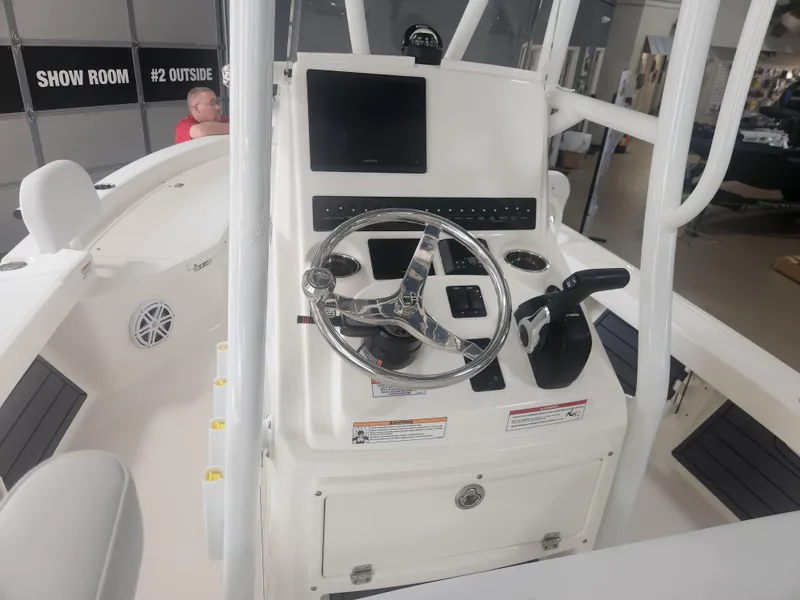 Slide: The Image of 2025 Pathfinder 2200 TRS boat console with steering wheel and controls in showroom. - 17