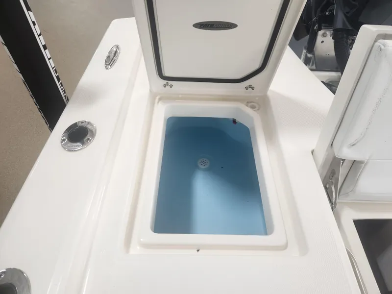 Slide: The Image of Open storage compartment on 2025 Pathfinder 2200 TRS boat, featuring a blue interior. - 25