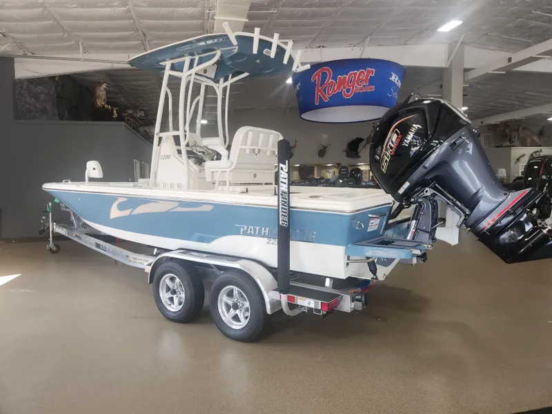 Slide: The Image of 2025 Pathfinder 2200 TRS boat on trailer in showroom, featuring Yamaha outboard motor. - 5