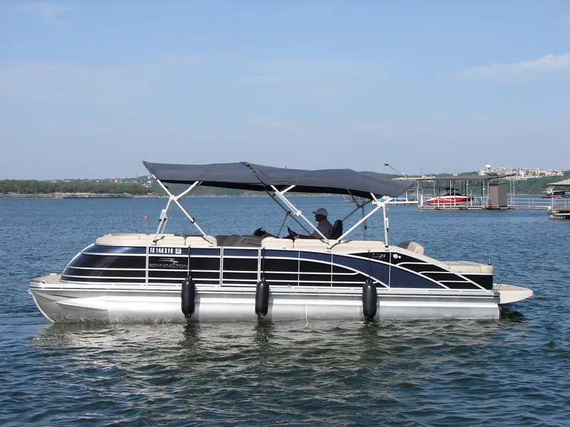 Slide: The Image of 2019 Bennington Q 25 QSBIO pontoon boat on a calm lake. - 1