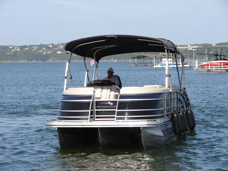 Slide: The Image of 2019 Bennington Q 25 QSBIO pontoon boat on a lake with canopy and American flag. - 11