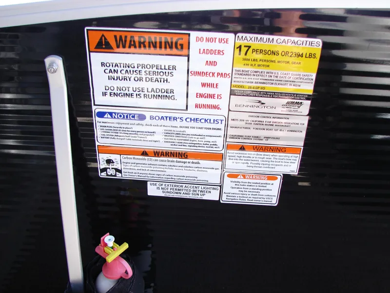 Slide: The Image of Warning labels and capacity information on a 2019 Bennington Q 25 QSBIO boat. - 28