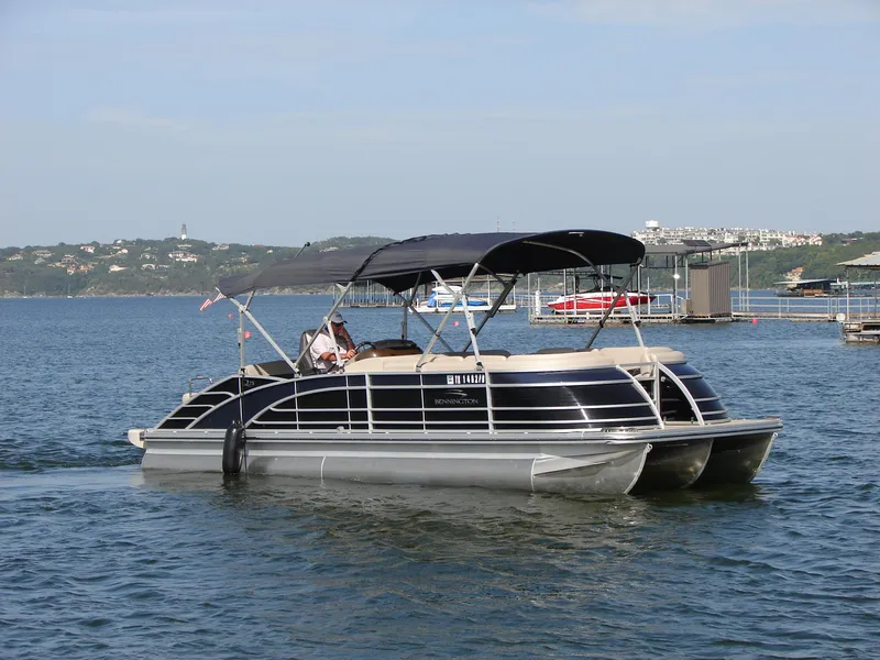 Slide: The Image of 2019 Bennington Q 25 QSBIO pontoon boat cruising on a lake with scenic background. - 8