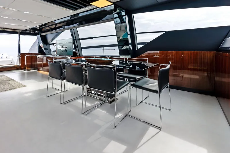 Slide: The Image of Modern dining area on the 2021 Riva 88' FOLGORE yacht with sleek black chairs and large windows. - 29