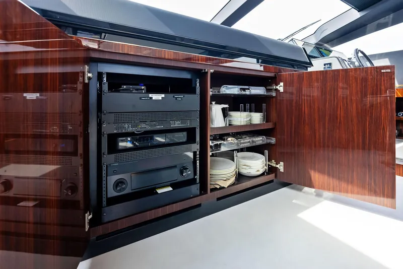 Slide: The Image of Open cabinet with electronics and dishware on a 2021 Riva 88' FOLGORE yacht. - 30
