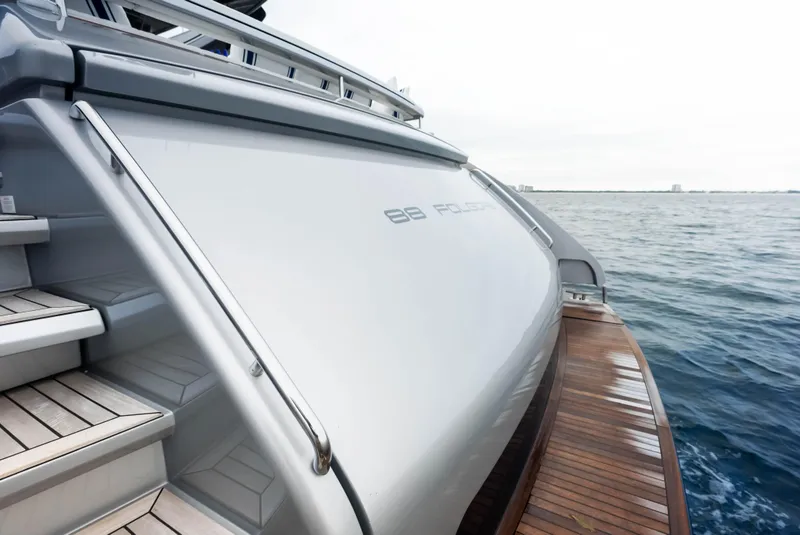 Slide: The Image of Riva 88' FOLGORE 2021 yacht stern view with wooden deck and ocean backdrop. - 9