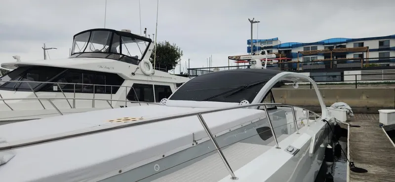 Slide: The Image of 2017 Trident Custom yacht docked at marina, featuring sleek design and modern architecture in background. - 26