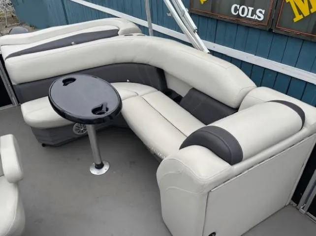 Slide: The Image of 2021 Sylvan Mirage 820 Cruise boat interior with cushioned seating and a small table. - 13