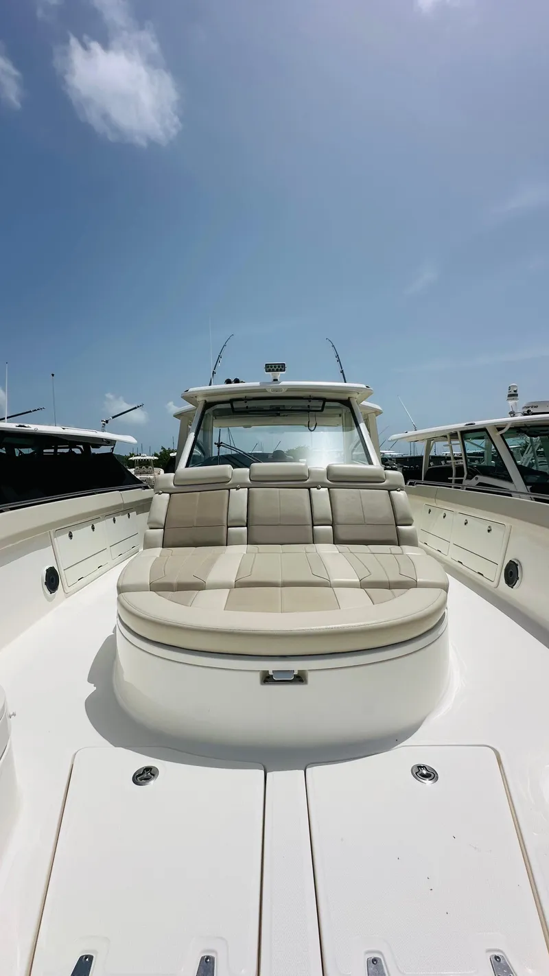 Slide: The Image of Boston Whaler 420 Outrage 2021 boat with spacious seating under a clear blue sky. - 11