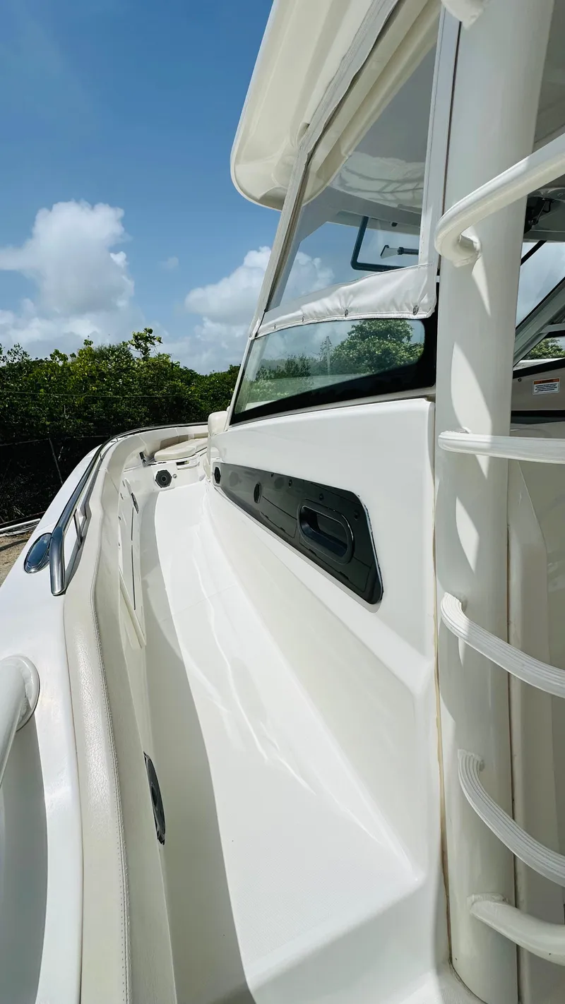 Slide: The Image of 2021 Boston Whaler 420 Outrage boat, side view, white exterior, clear sky background. - 14