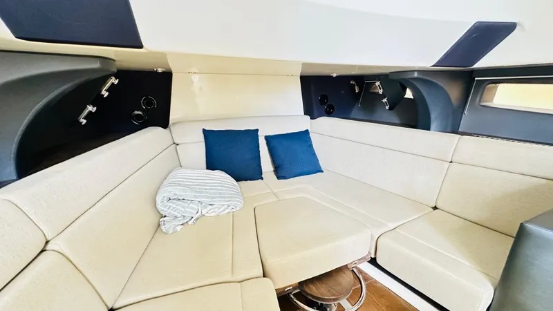 Slide: The Image of Interior of 2021 Boston Whaler 420 Outrage with beige seating and blue cushions. - 17