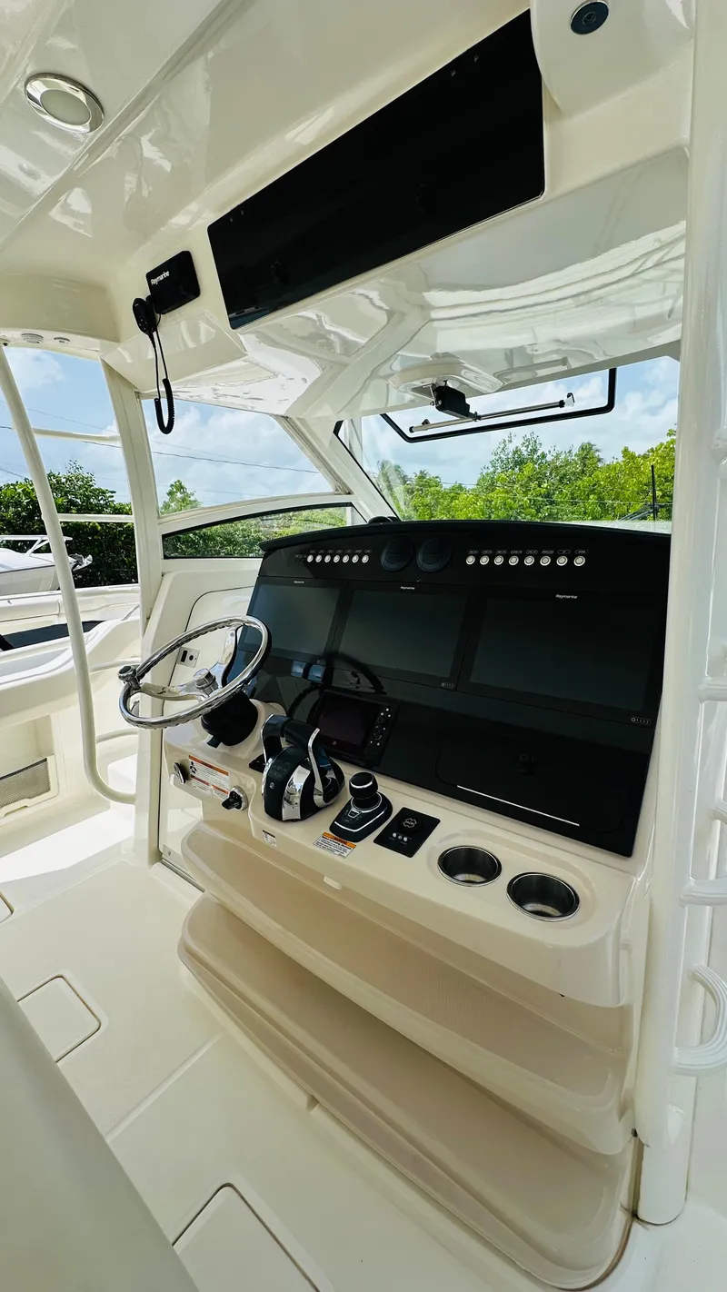 Slide: The Image of 2021 Boston Whaler 420 Outrage helm with modern controls and steering wheel. - 9