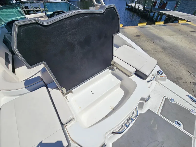 Slide: The Image of 2017 Chaparral 246 SSi boat interior with open storage compartment near dock. - 16