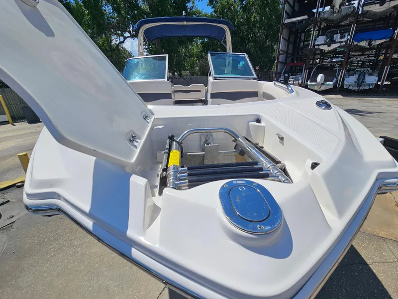Slide: The Image of 2017 Chaparral 246 SSi boat with open storage compartment, docked outdoors. - 38