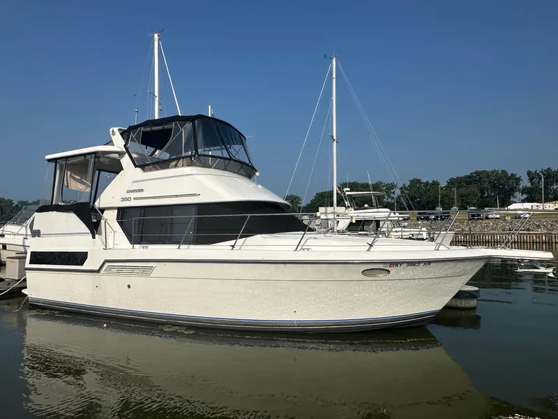 The Image of 1993 Carver 350 Aft Cabin yacht docked in a marina under clear blue skies. - 0
