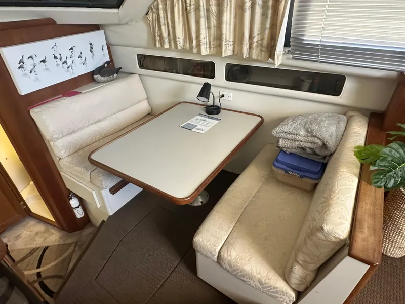 Slide: The Image of 1993 Carver 350 Aft Cabin interior with dining area, cushioned seating, and decorative elements. - 11