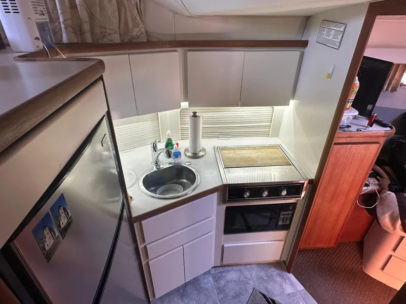 Slide: The Image of Compact kitchen area in a 1993 Carver 350 Aft Cabin yacht, featuring modern appliances. - 12
