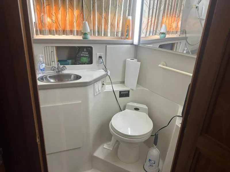 Slide: The Image of 1993 Carver 350 Aft Cabin bathroom with sink, toilet, and toiletries. - 16