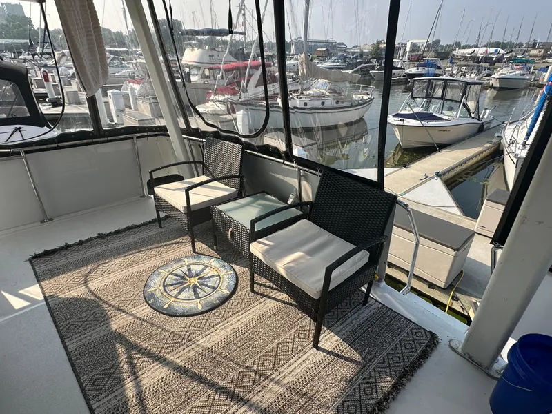 Slide: The Image of 1993 Carver 350 Aft Cabin yacht interior with seating, rug, and marina view. - 6