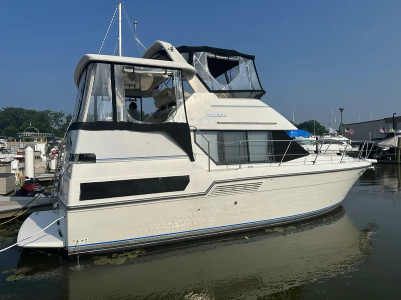 Slide: The Image of 1993 Carver 350 Aft Cabin yacht docked at marina under clear blue sky. - 1