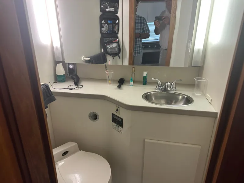 Slide: The Image of 1993 Carver 350 Aft Cabin bathroom with sink, mirror, and toiletries. - 19