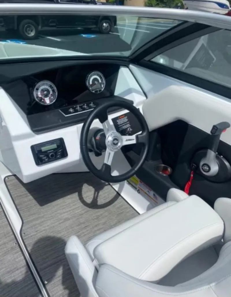 Slide: The Image of 2025 Four Winns H2 Freedom boat interior with steering wheel and dashboard controls. - 6
