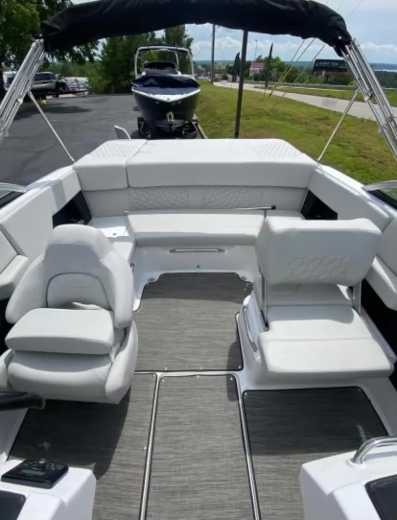 Slide: The Image of 2025 Four Winns H2 Freedom boat interior with white seating and gray flooring. - 8