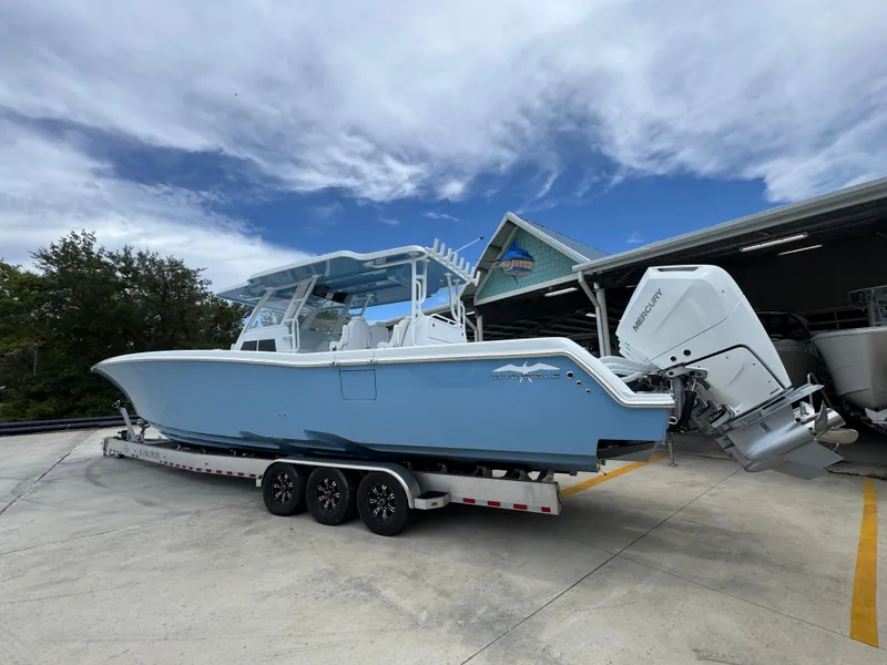 Slide: The Image of 2026 Invincible 43 Open Fisherman boat on trailer, parked outdoors under a cloudy sky. - 12