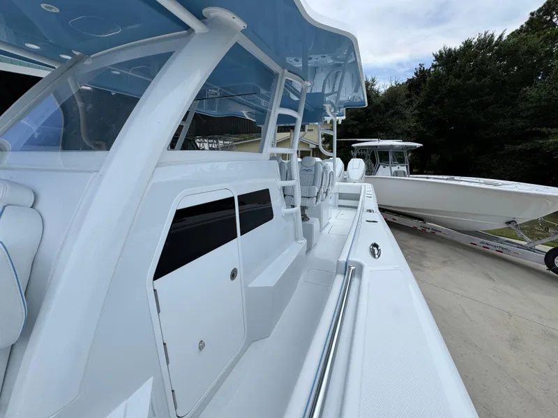 Slide: The Image of 2026 Invincible 43 Open Fisherman boat, sleek design, spacious deck, parked outdoors. - 20