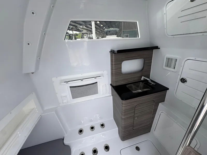Slide: The Image of Interior of 2026 Invincible 43 Open Fisherman boat, featuring a compact sink and storage area. - 29