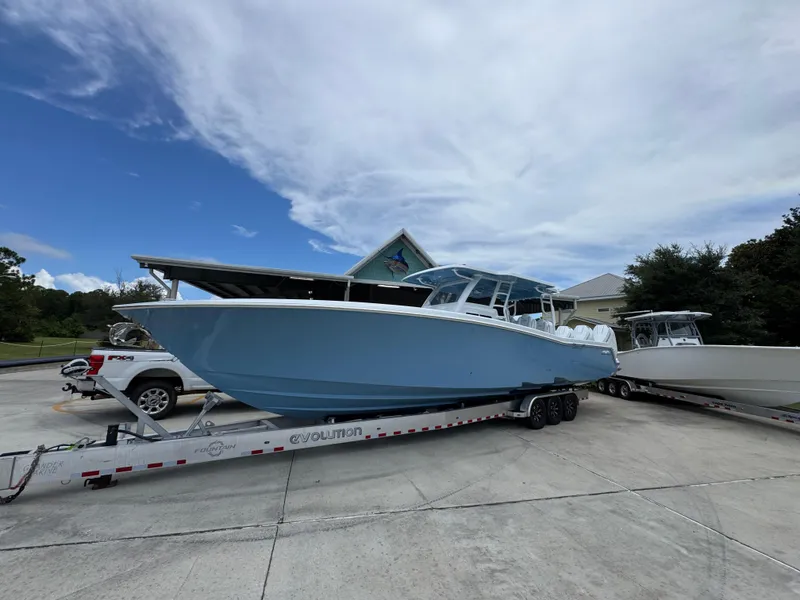 Slide: The Image of 2026 Invincible 43 Open Fisherman boat on trailer, parked outdoors under cloudy sky. - 3