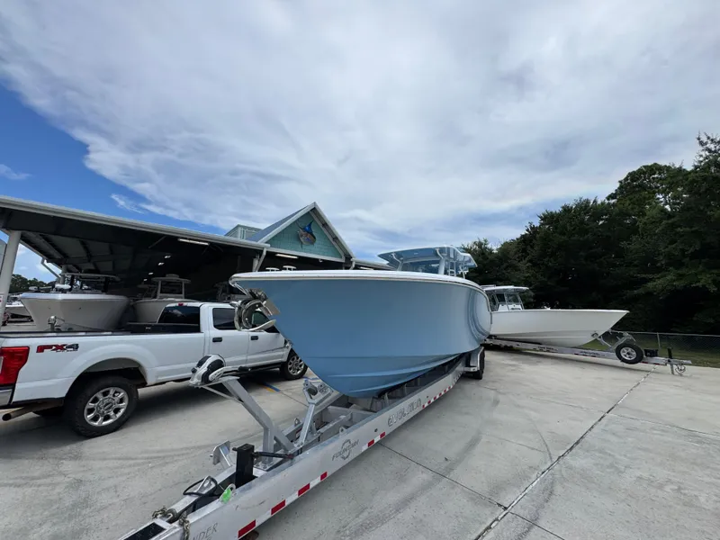 Slide: The Image of 2026 Invincible 43 Open Fisherman boat on trailer, parked beside a white truck. - 5