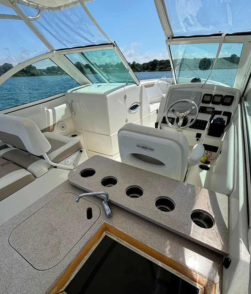 Slide: The Image of 2015 Sailfish 275 DC boat interior with steering wheel, seating, and cup holders. - 11