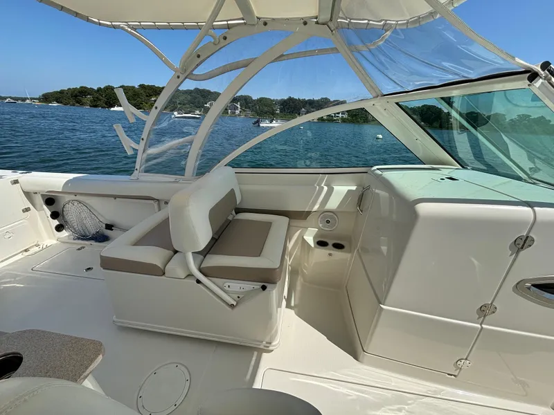 Slide: The Image of 2015 Sailfish 275 DC boat interior with seating, clear canopy, and scenic water view. - 13